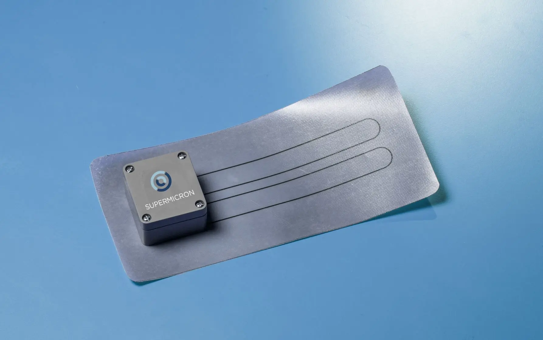Sensore SuperMicron: unita di acquisizione e striscia sensibile Smart Skin Sensor su fondo blu.